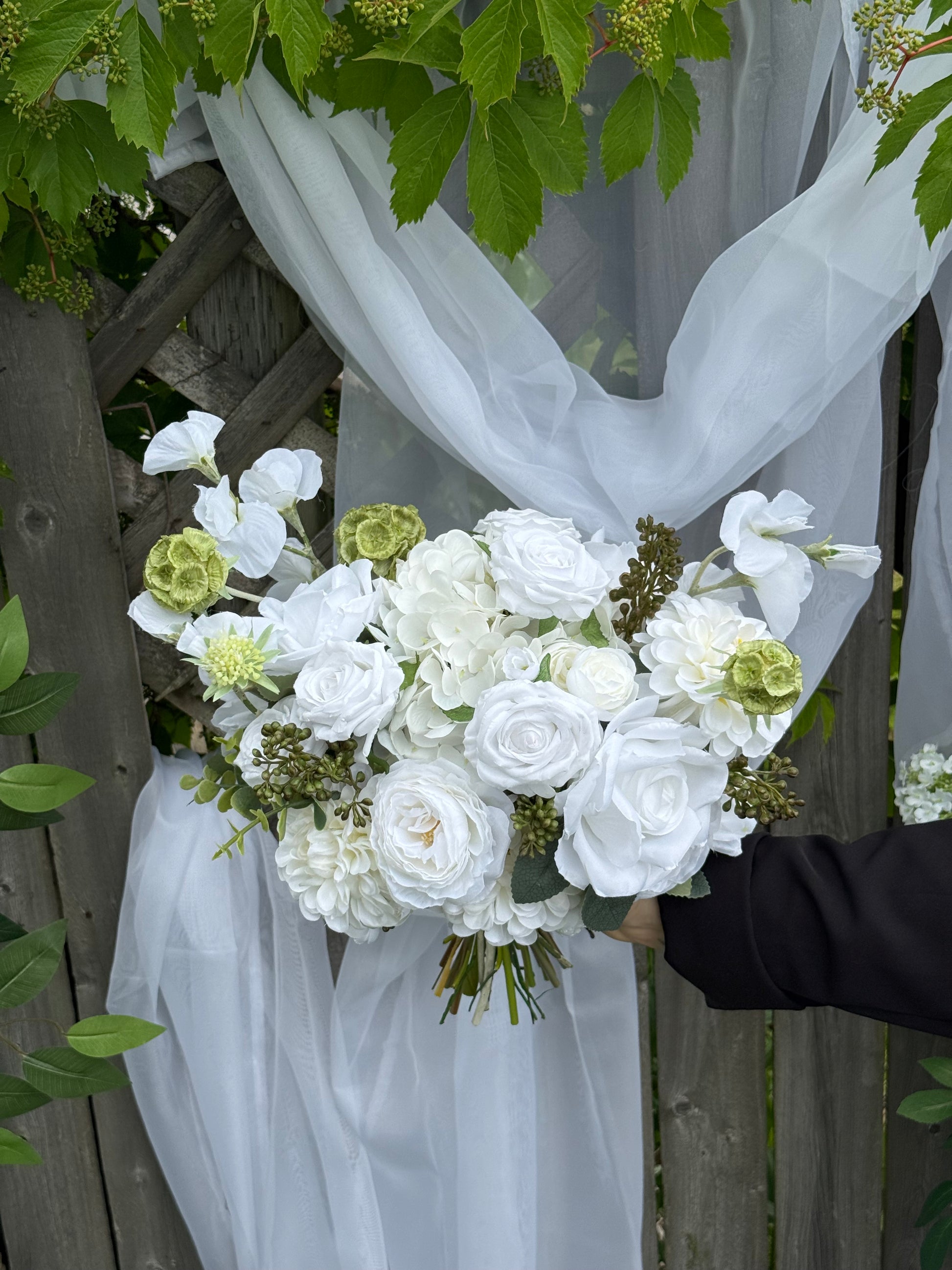 Classic modern faux white bridal bouquet with roses, dahlias, hydrangeas, scabiosa balls and berries 