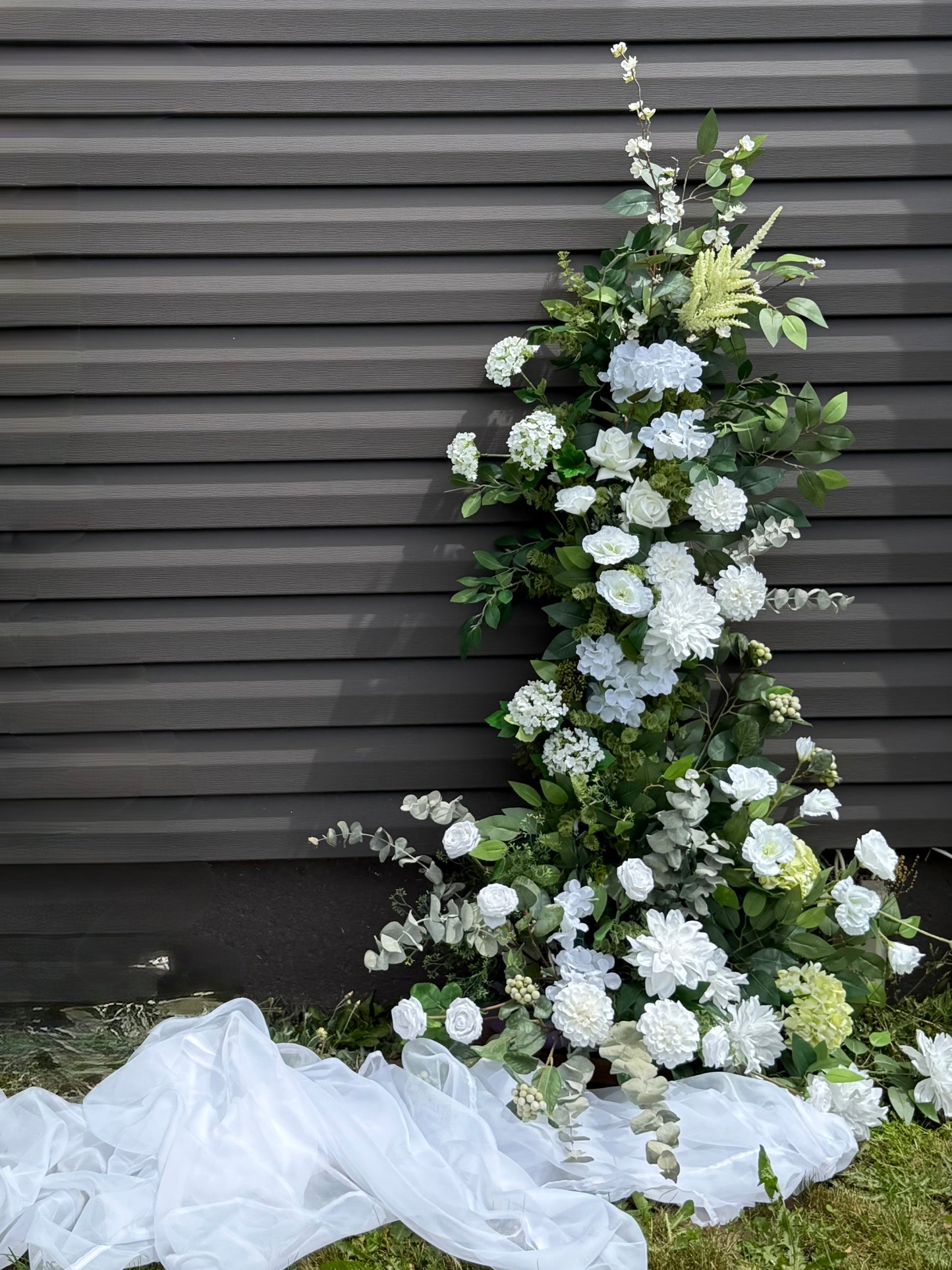 Garden white classic broken arch with hydrangeas, dahlias, roses, eucalyptus and brunches