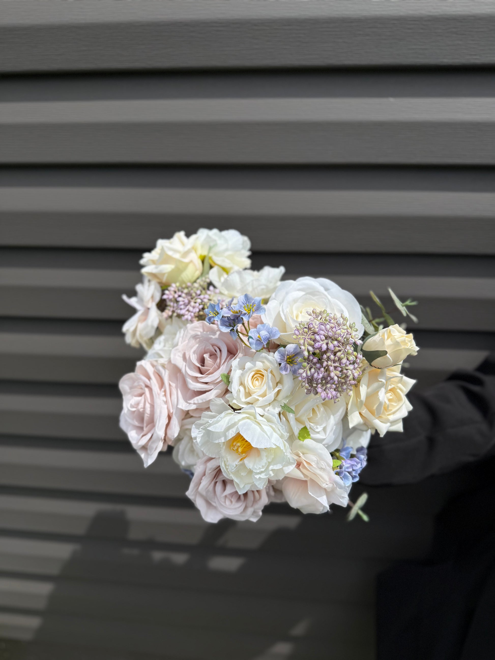 Pastel bridal bouquet with cream roses, garden roses and delicate blue accents. Classic and perfect