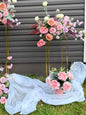 Modern floral arrangement with pink and peach, purple flowers on a grey backdrop. 