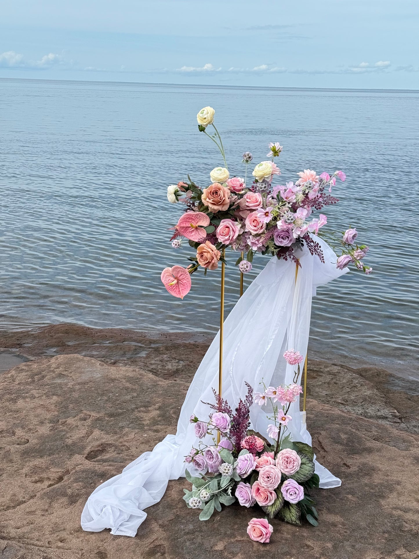 Ocean wedding, broken arch, bright pastel floral decor, golden stands