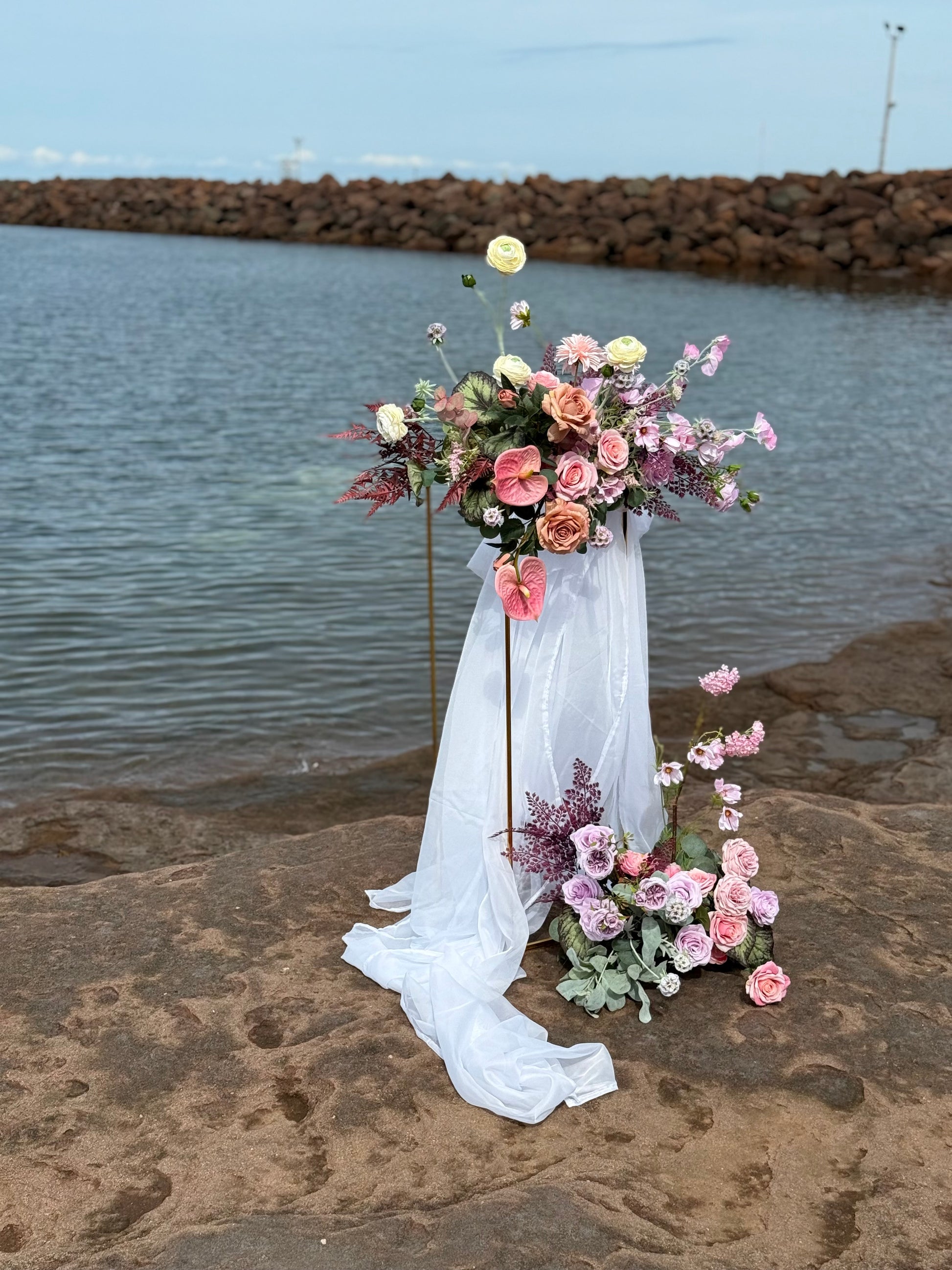 Ocean style pink and purple wedding golden stand with flowers 