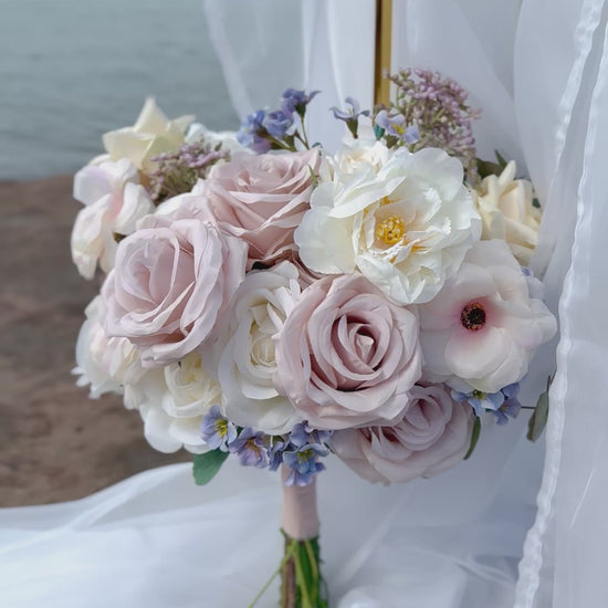 Pastel bridal bouquet with cream roses, garden roses and delicate blue accents. Classic and perfect