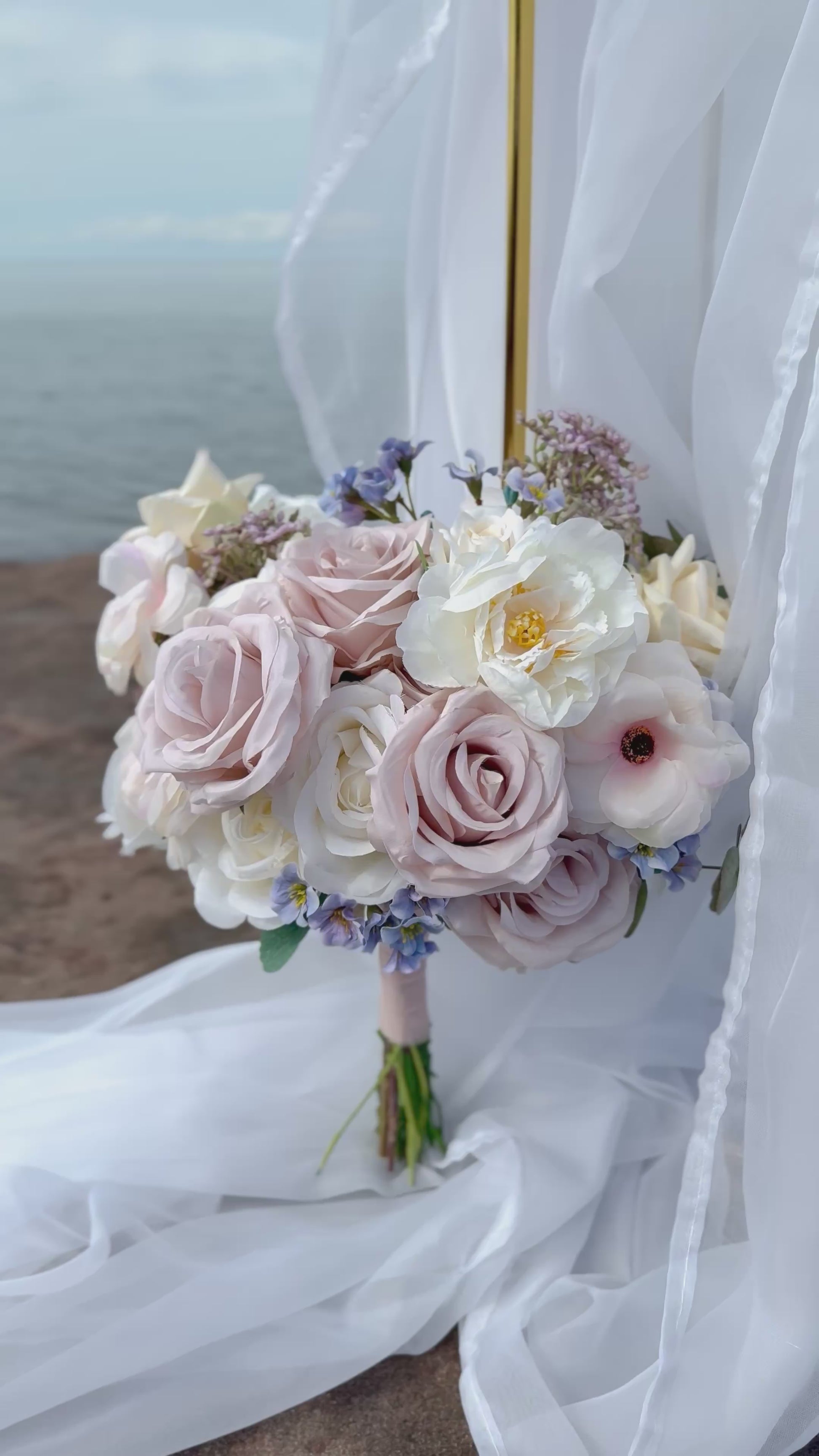 Pastel bridal bouquet with cream roses, garden roses and delicate blue accents. Classic and perfect