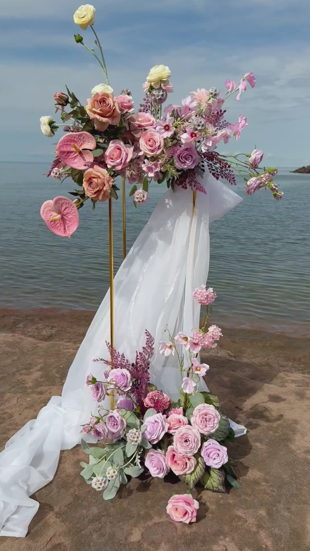 Ocean style pink and purple wedding golden stand with ranunculus, anthurium, roses and wild flowers